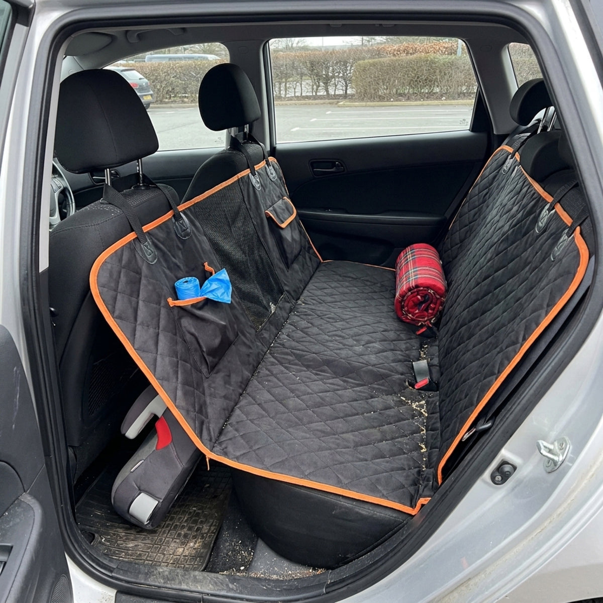 Black quilted hammock seat cover fitted empty across a car back bench