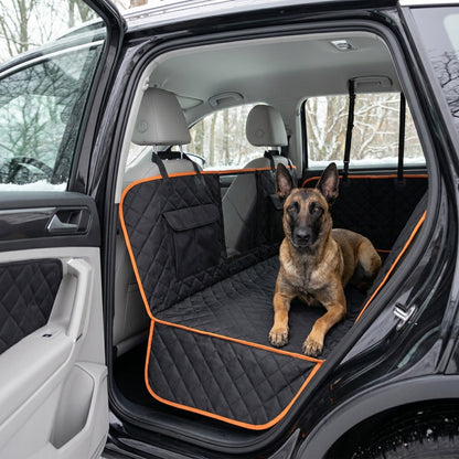 Belgian Malinois resting on the black quilted hammock seat cover, side flaps covering both door panels, winter trees outside